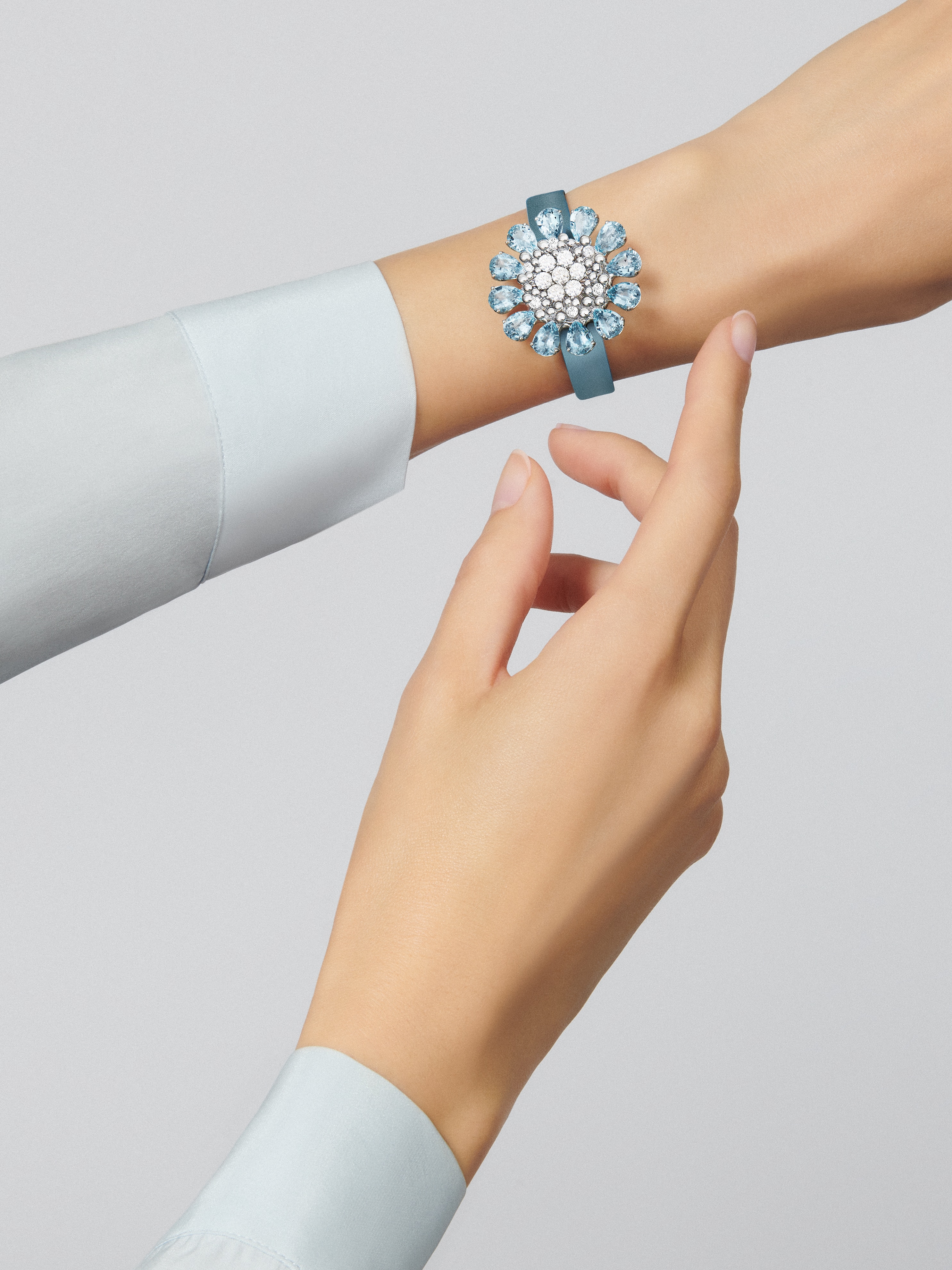 Fleurs d'Hawaï隐秘式腕表, 18K白金, 海蓝宝石:  12颗,  10.8 克拉, 珍珠母贝:  1 宝石, 钻石:  59颗,  2.63 克拉, Worn Detail, Watch_梵克雅宝_Van Cleef & Arpels