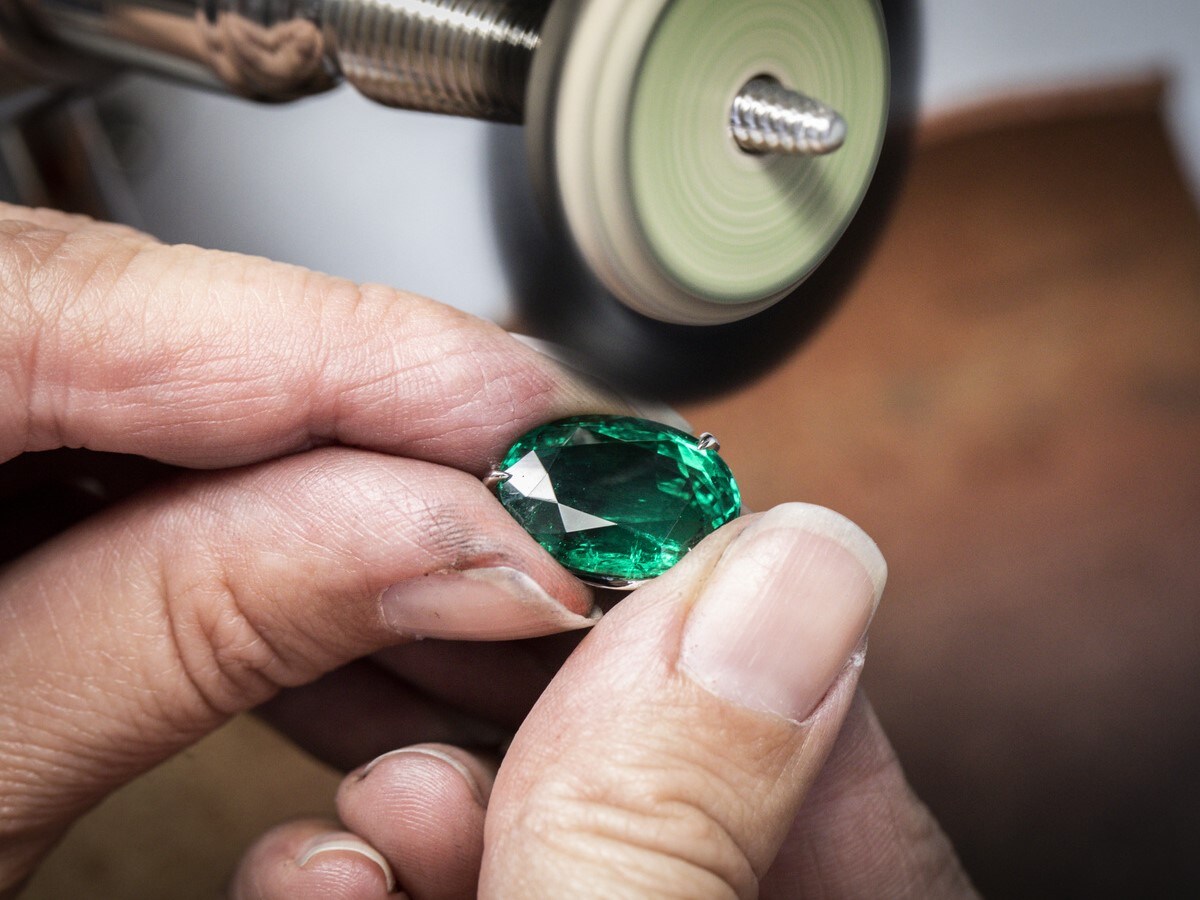 Brush polishing an oval-cut emerald set on the Piazza divina transformable necklace. Le Grand Tour raconté par Van Cleef & Arpels collection, Van Cleef & Arpels.