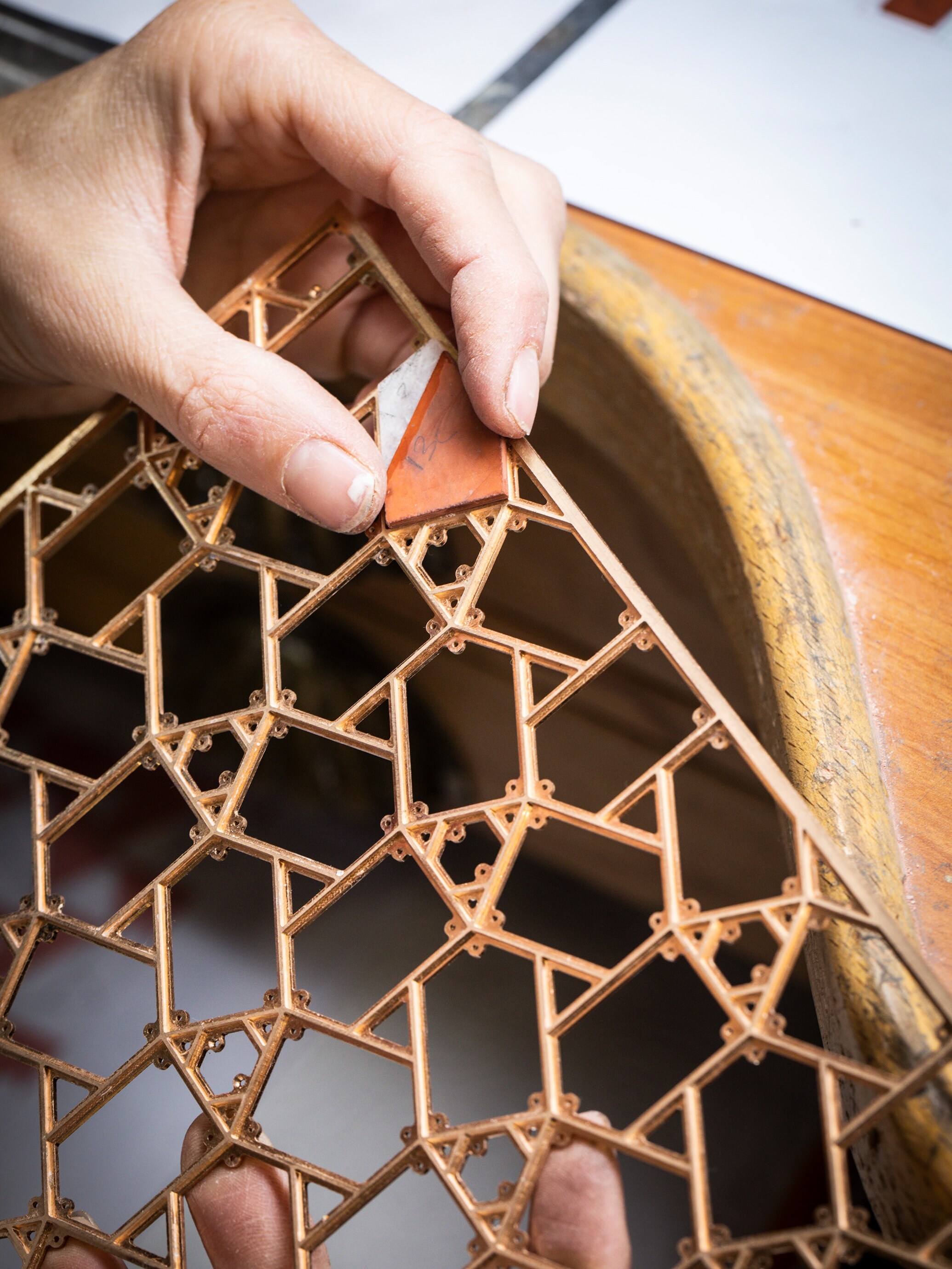 Positioning the red jasper and mother-of-pearl elements on the gold structure. Precious boxes, Van Cleef & Arpels.