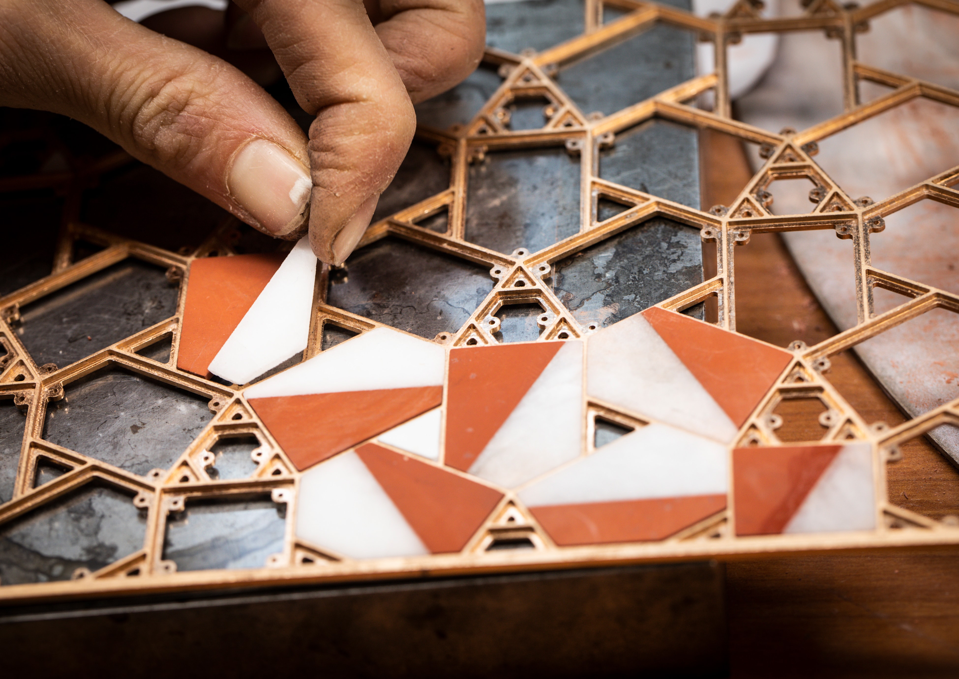 Positioning the red jasper, white quartzite and mother-of-pearl elements on the gold structure. Precious boxes, Van Cleef & Arpels.