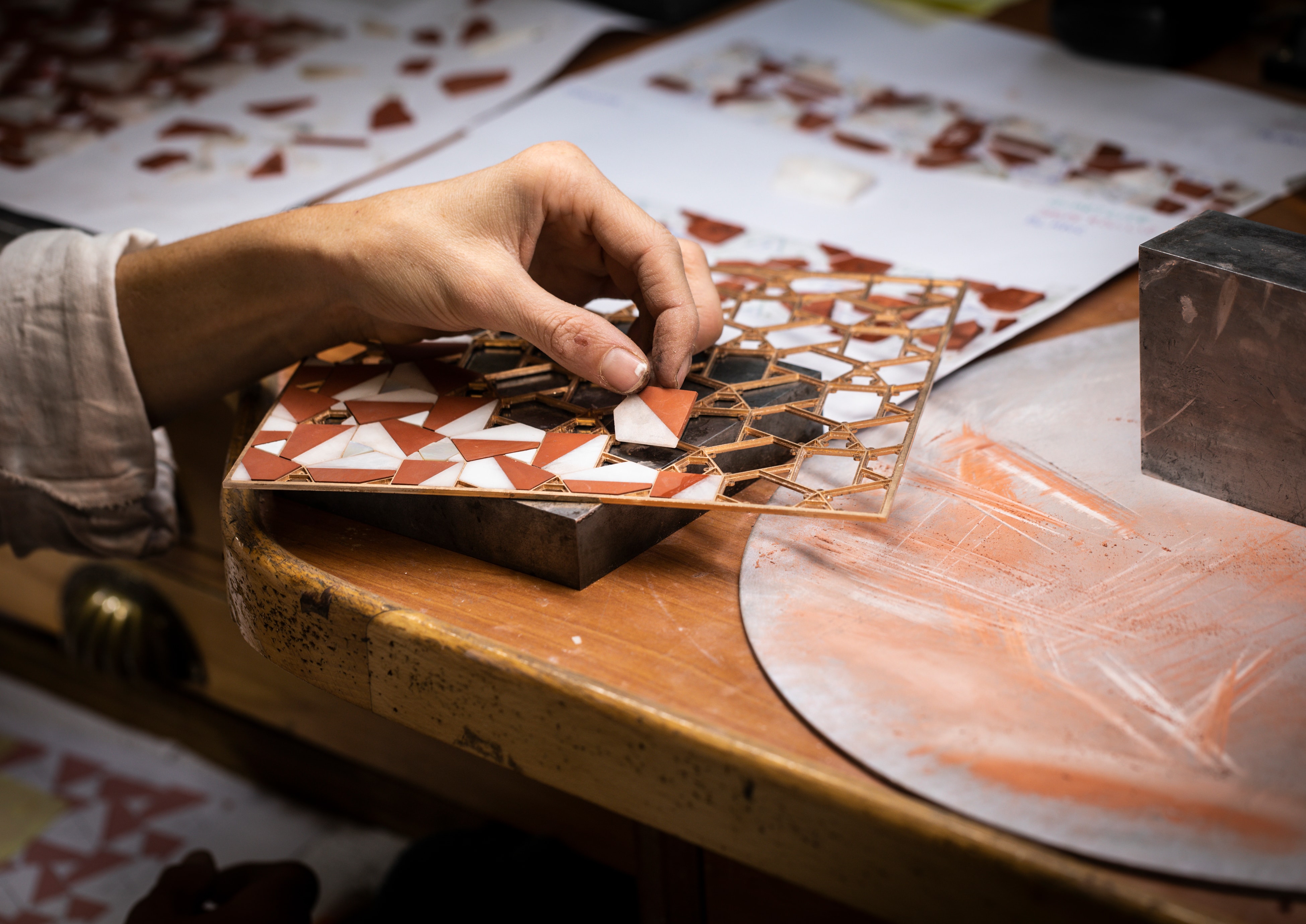 Controlling the setting of the red jasper, white quartzite, agate and mother-of-pearl elements on the gold structure. Precious boxes, Van Cleef & Arpels.