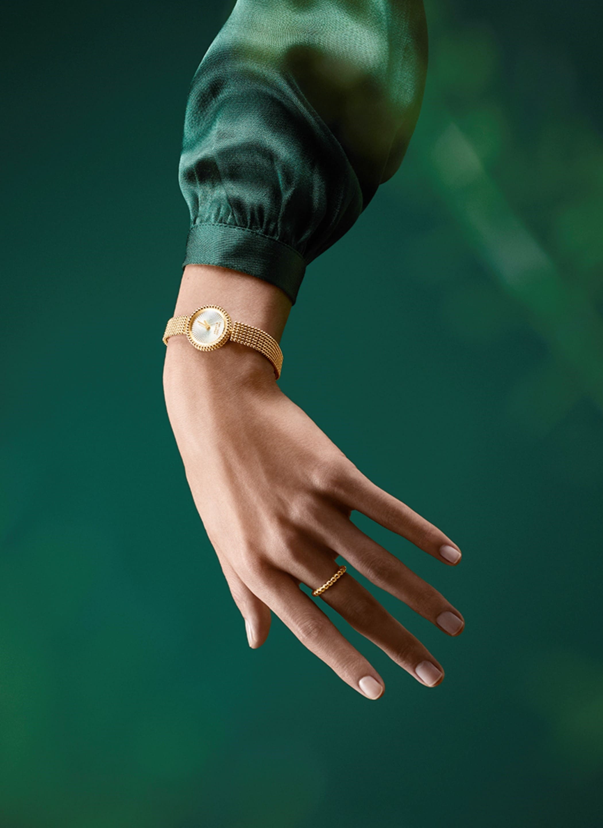 Perlée watch, 23-mm case in 18K yellow gold, guilloché white mother-of pearl, bracelet in 18K yellow gold, guilloché white mother-of-pearl, Swiss quartz movement. Perlée collection, Van Cleef & Arpels.