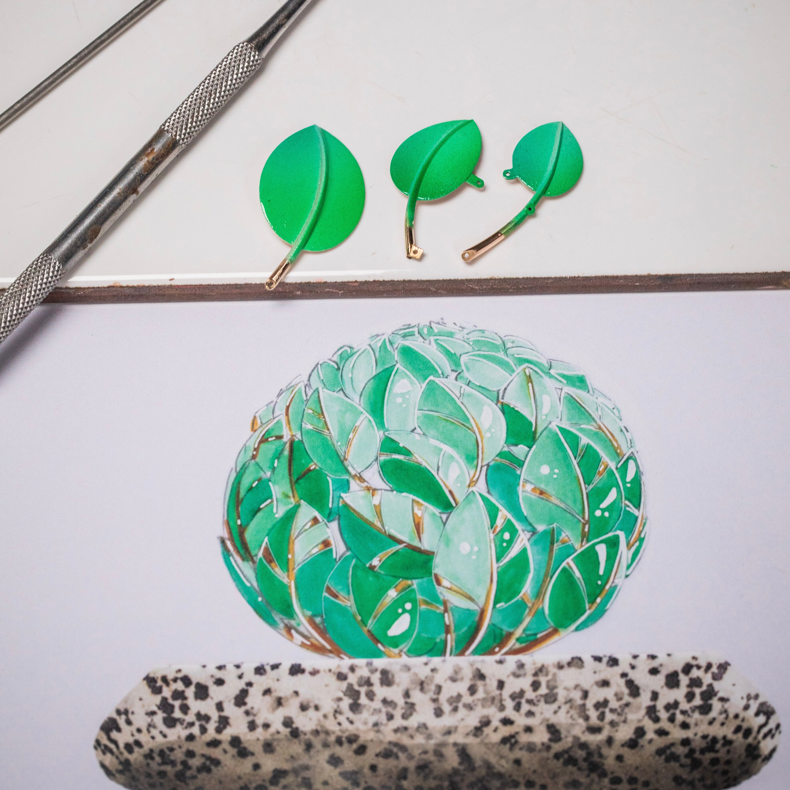 将漆面叶片与设计原稿进行对比。Apparition des Baies自动机械装置，Extraordinary Objects非凡工艺臻品系列，Van Cleef & Arpels梵克雅宝。