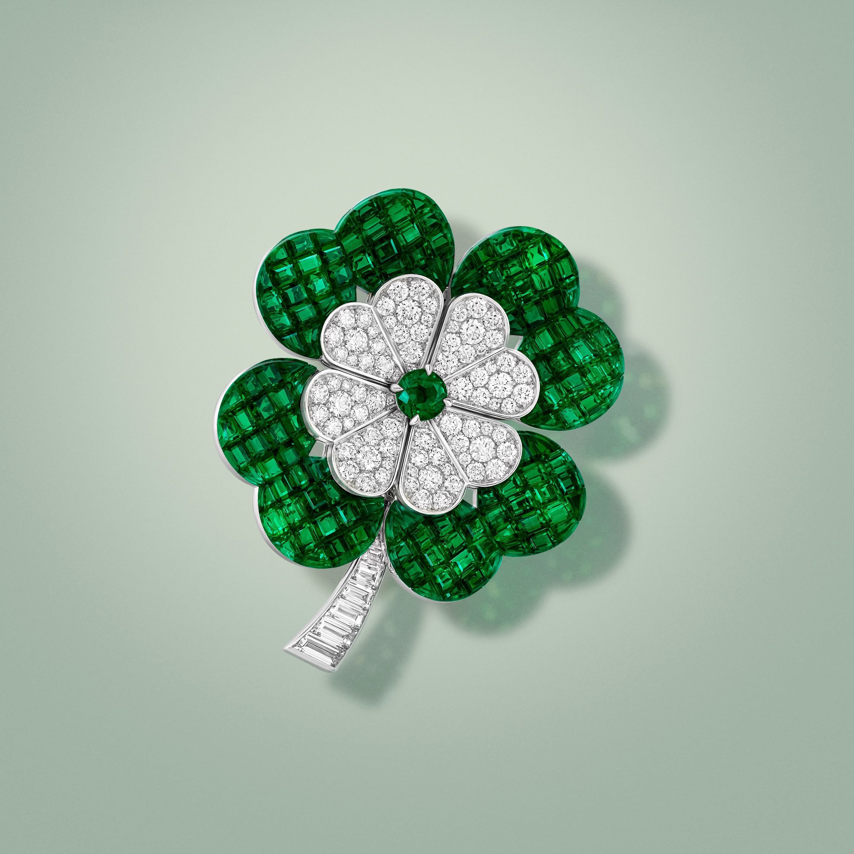 Trèfle Mystérieux clip. 18K white gold, 18K rose gold, Traditional Mystery Set™ emeralds, emerald, diamonds. Flowers collection, Van Cleef & Arpels.