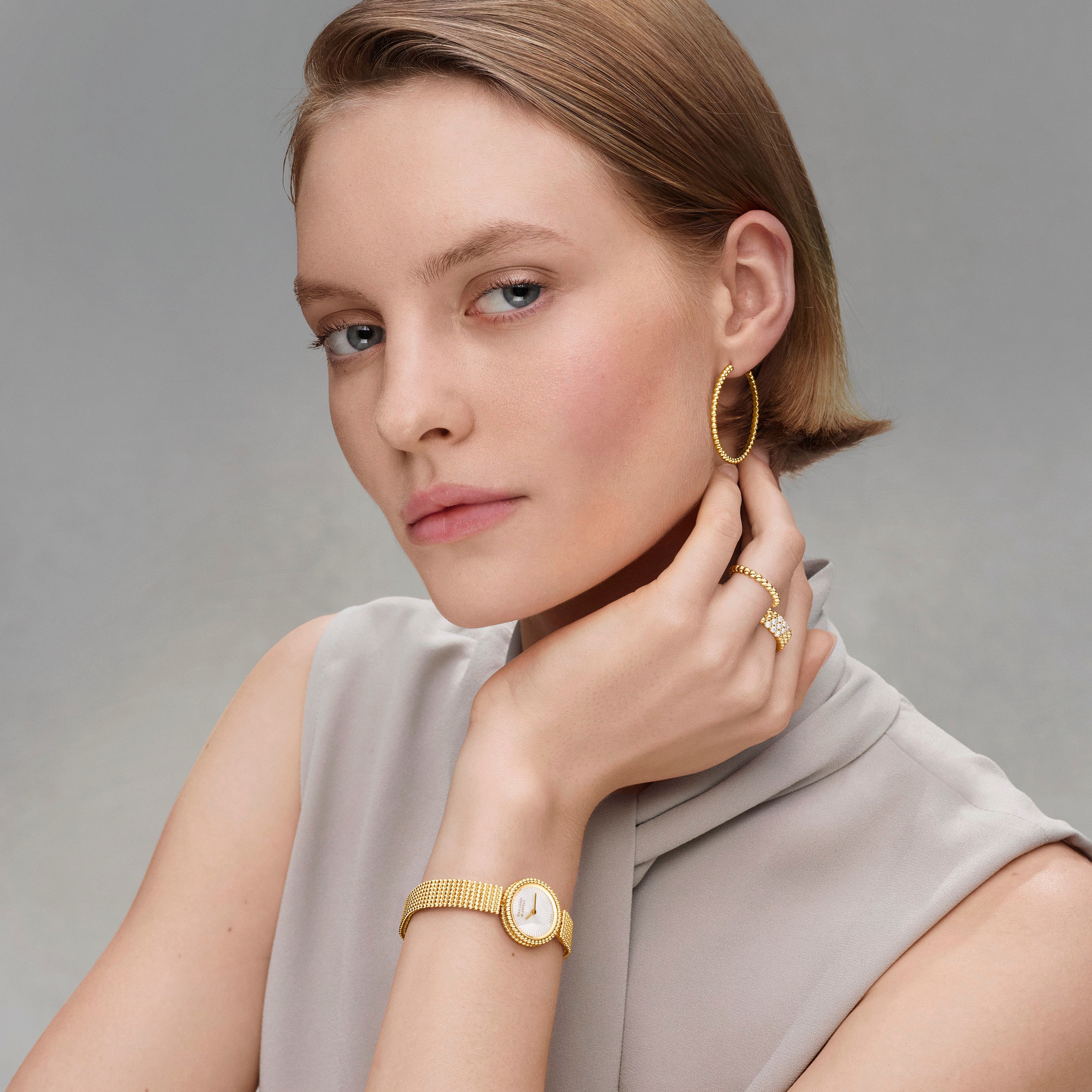 腕表，23毫米，黄K金，玑镂雕花白色珍珠母贝，瑞士石英机芯；pearls of gold环形耳环和戒指。Perlée系列，Van Cleef & Arpels梵克雅宝。