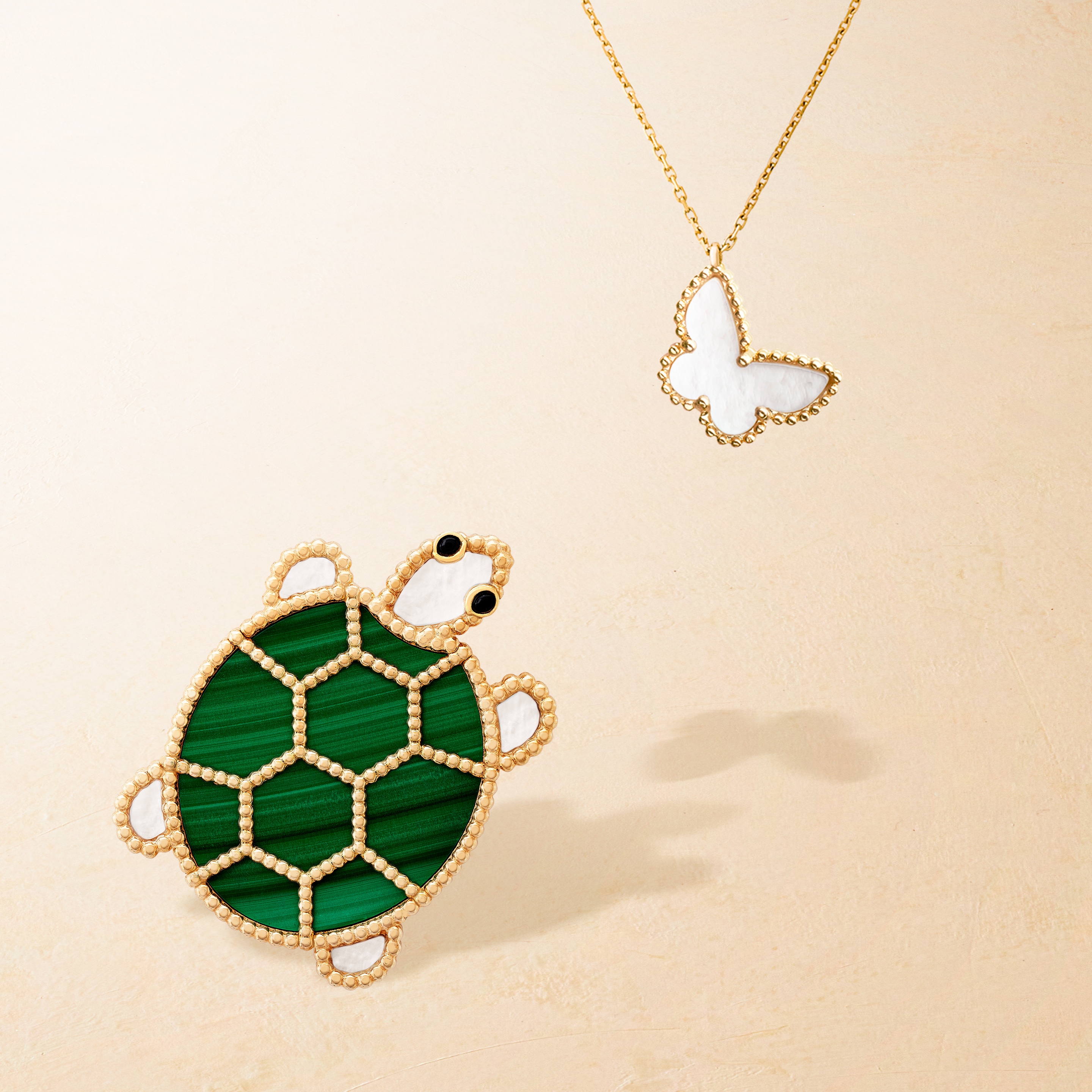 Lucky Animals Turtle clip, yellow gold, malachite, mother-of-pearl, onyx. Sweet Alhambra® butterfly pendant, yellow gold, mother-of-pearl. Van Cleef & Arpels