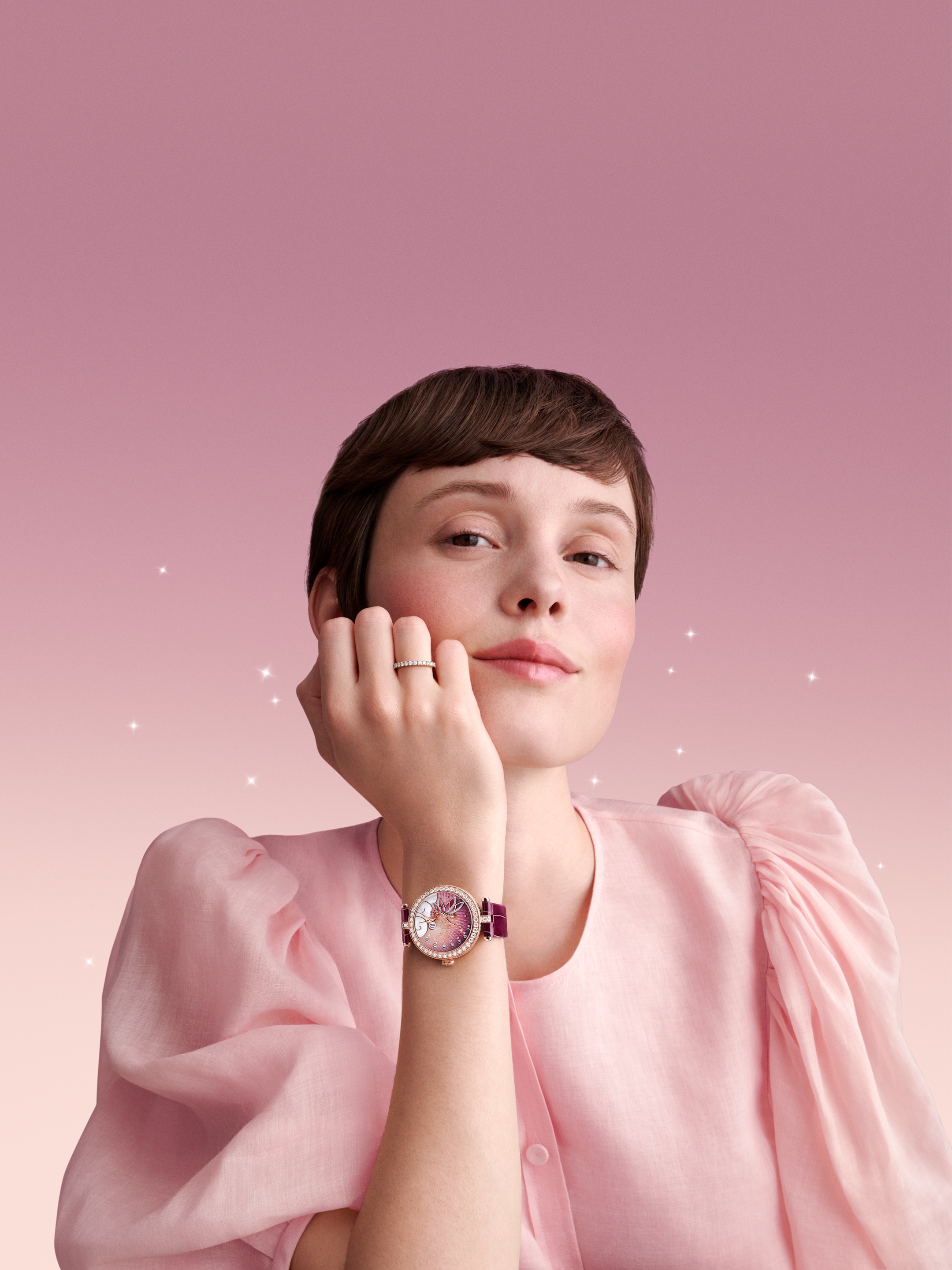 Lady Féerie Or Rose腕表,玫瑰金、镀铑白K金、粉红色蓝宝石、钻石、珍珠母贝、珐琅,自动上链机械机芯,跳时及逆跳分针。腕表附两条可替换表带和一个可替换镶钻针式表扣。Poetic Complications诗意复杂功能腕表系列,Van Cleef & Arpels梵克雅宝。