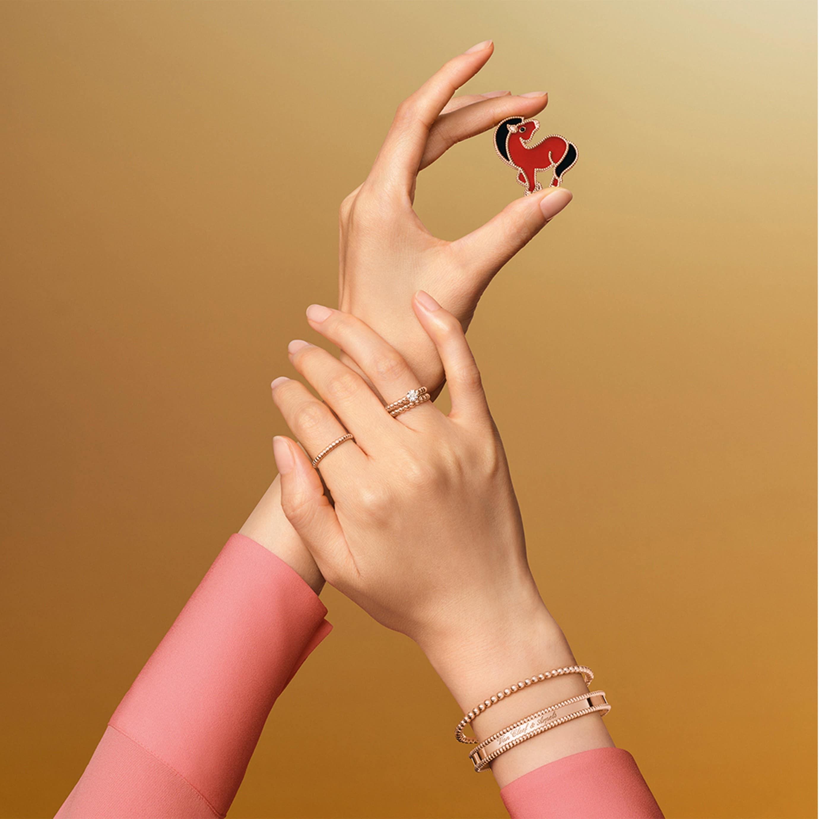 "Lucky Animals Horse clip, 18K rose gold, carnelian, onyx. Lucky Animals® collection, Van Cleef & Arpels. Perlée solitaire, 18K rose gold, one round 0.50 ct EVVS2 diamond. Perlée pearls of gold ring, small model, 18K rose gold. Perlée pearls of gold ring, medium model, 18K rose gold. Perlée pearls of gold bracelet, 18K rose gold, medium model. Bracelet Perlée signature, or rose, moyen modèle. Perlée® collection, Van Cleef & Arpels."